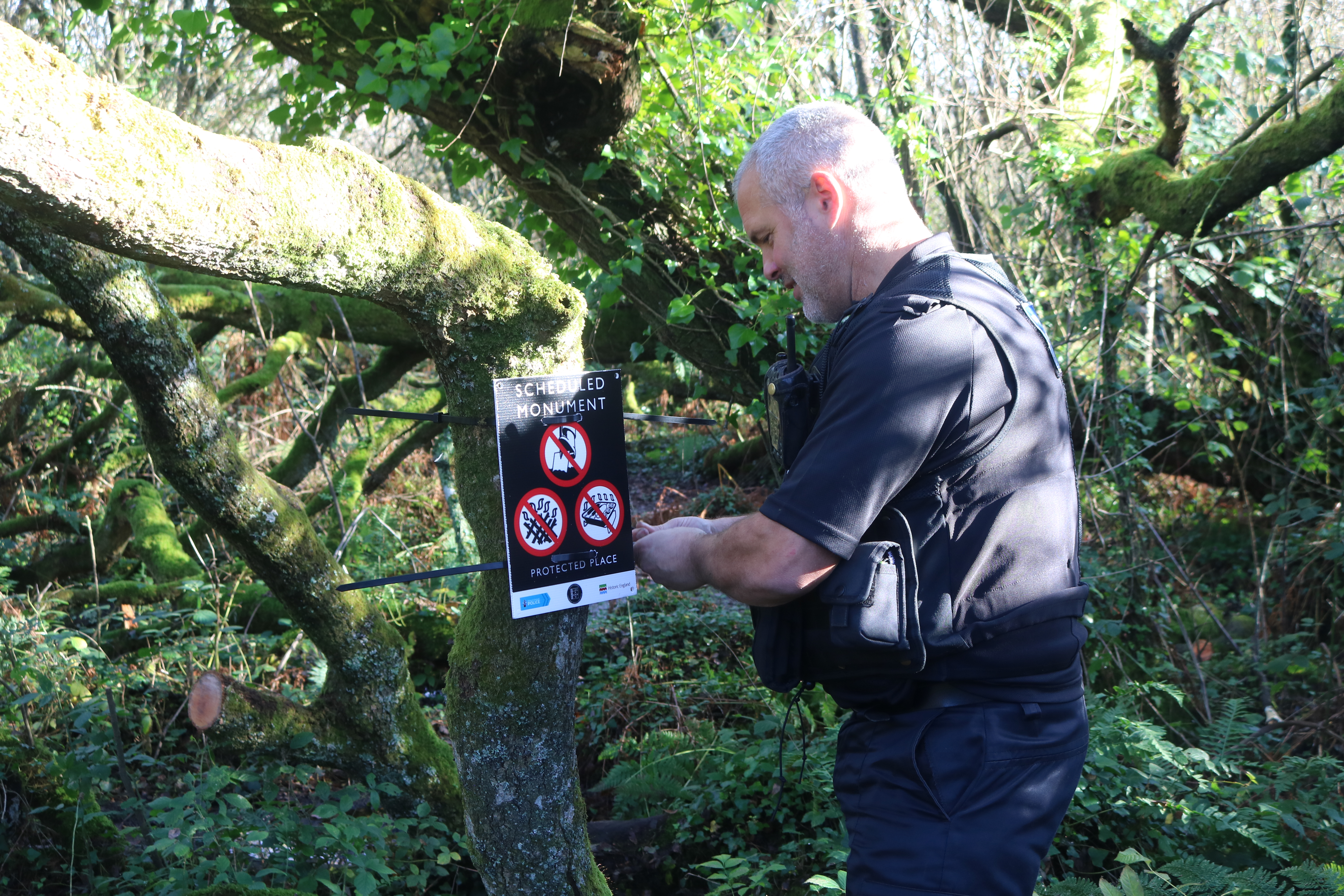 Devon and Cornwall Heritage Crimes Officer erecting signs around Madron Well in response to fire damage